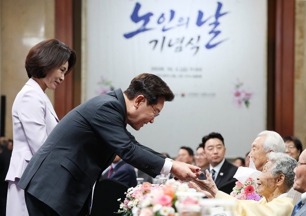 ▲이재명 대통령이 2일 서울 한 호텔에서 열린 제30회 노인의 날 기념식에서 100세 어르신들에게 명아주로 만든 지팡이인 청려장을 전달하고 있다. 연합뉴스